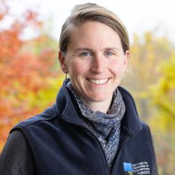 Leah Hart poses outside on the deck of the Conservation Center in autumn.