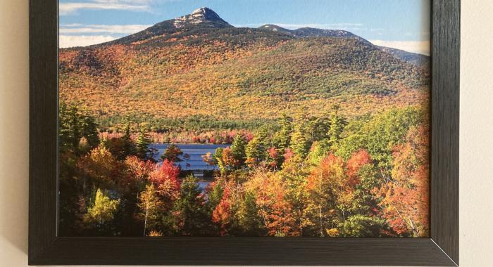 a framed photograph of a lake and mountain during autumn 