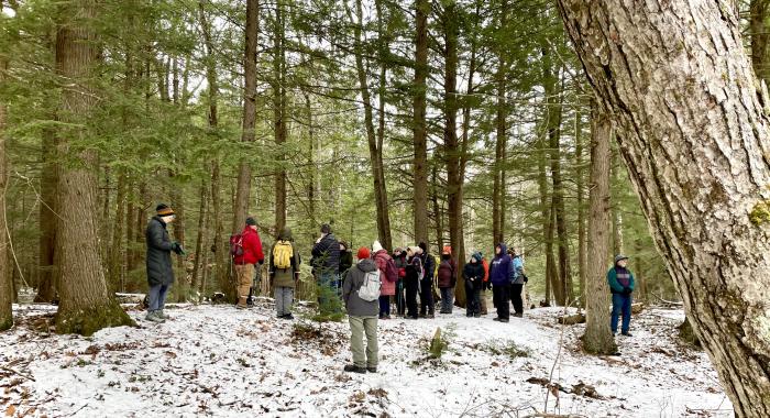 a group of hikers stands together in a snowy forest