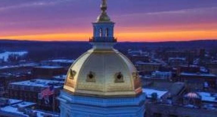 NH State Capital dome against sunrise sky