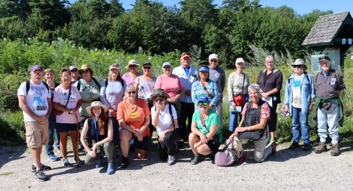 colorful hiking group poses for parking lot selfie in Rochester