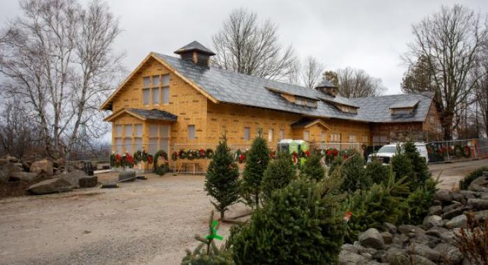 The Rocks' Carriage Barn under construction with Christmas trees and wreaths for sale out front.