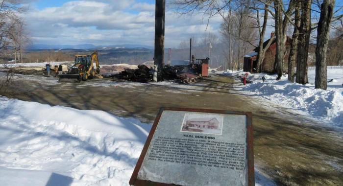   The 115-year-old Tool Building at The Rocks, depicted in this sign at the Bethlehem property owned by the Forest Society, was reduced to rubble, apart from its tall chimney by a fast-moving fire on Feb. 13. 