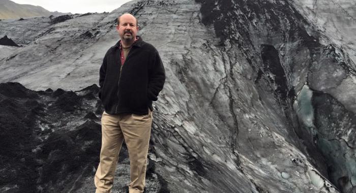 Dr. Mann stands atop a glacier.