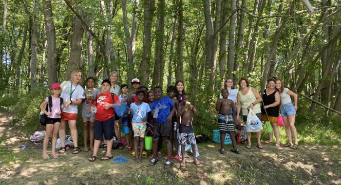 Students pose for a group photo in the shade of silver maple forest