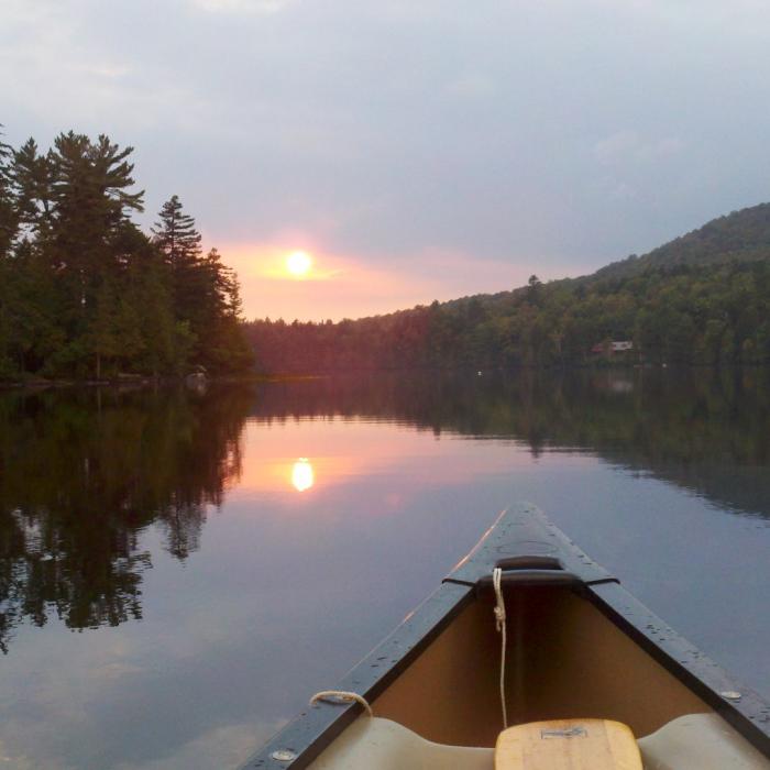 Sunset view of a lake from a kayak.
