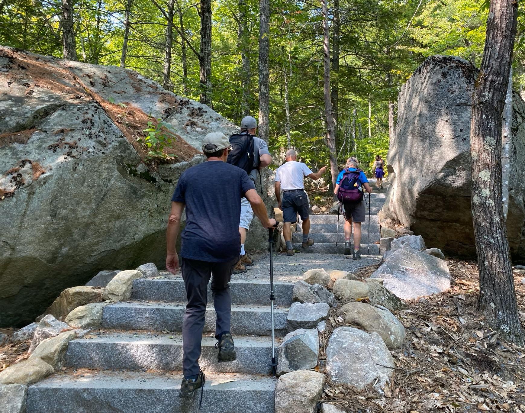 Hikers walk up new granite steps on the Main Trail.