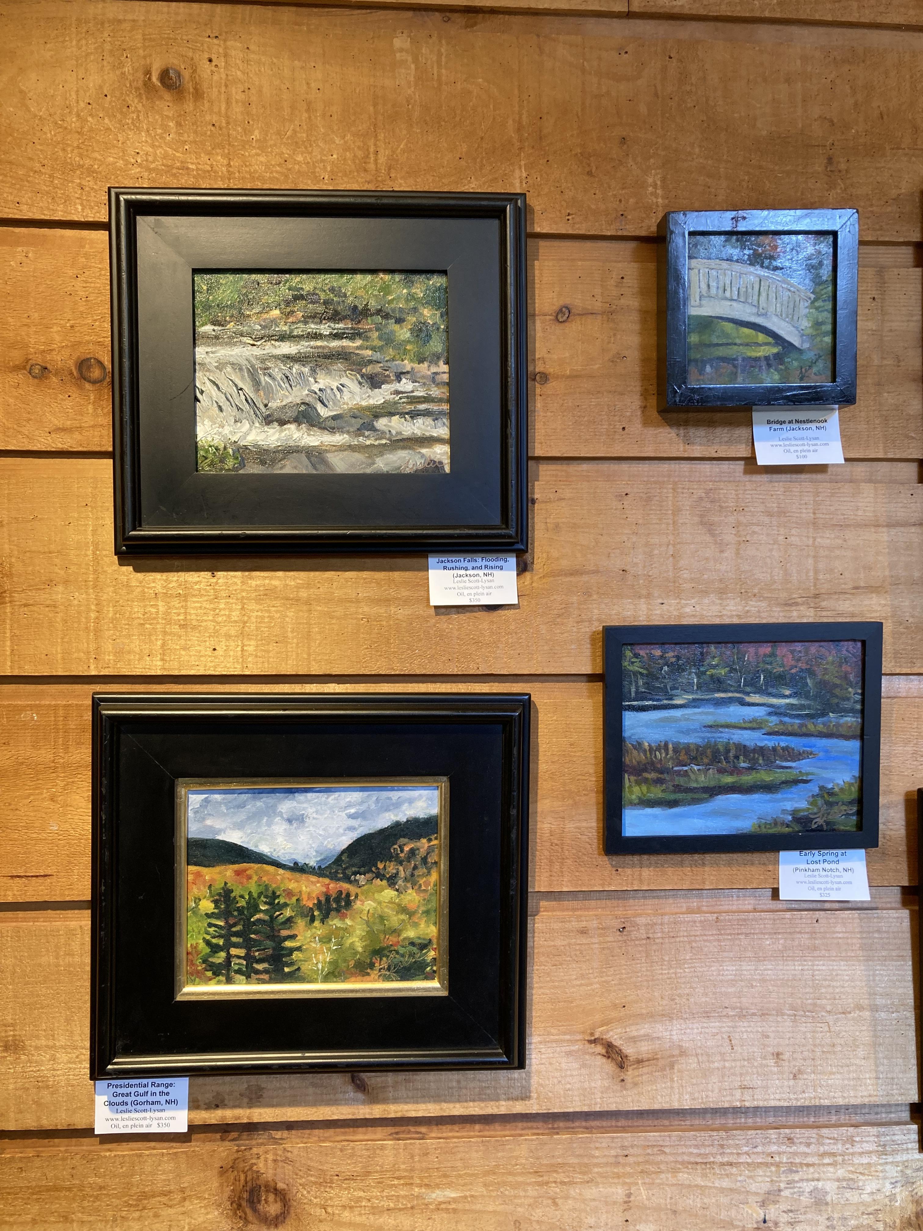 Four framed oil paintings against a wooden back drop