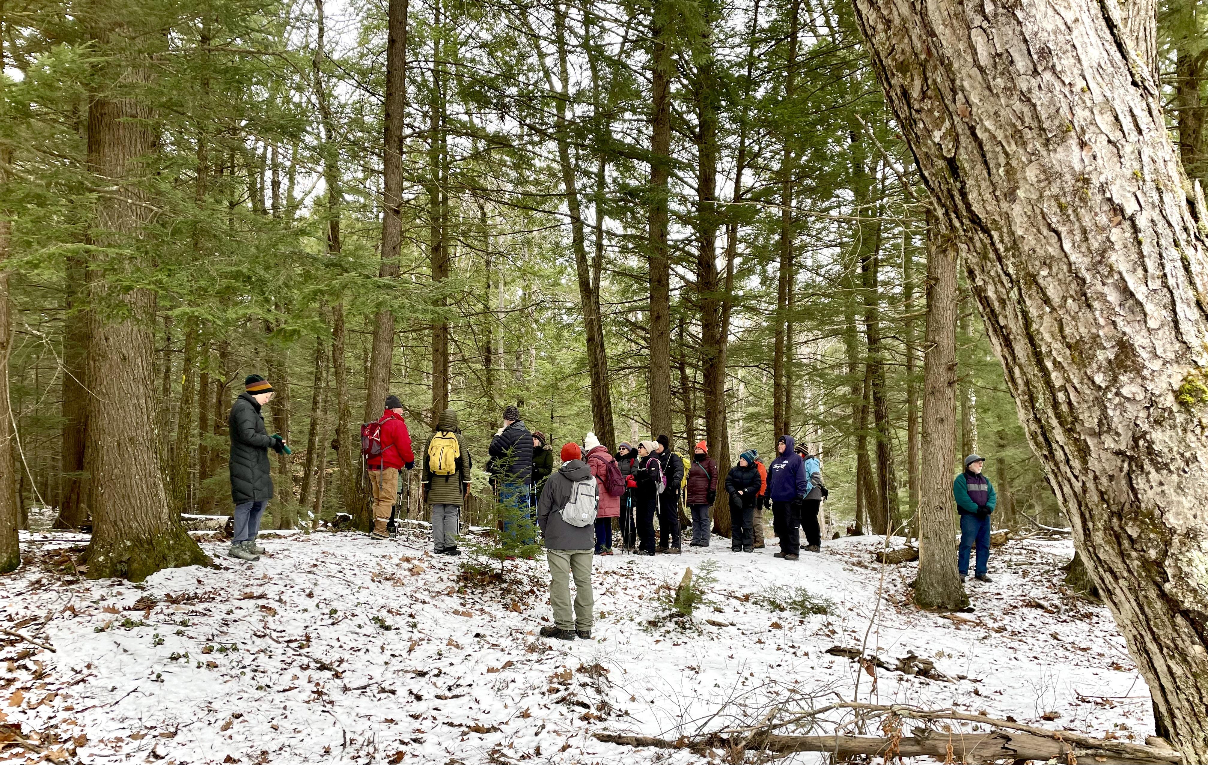 a group of hikers stands together in a snowy forest