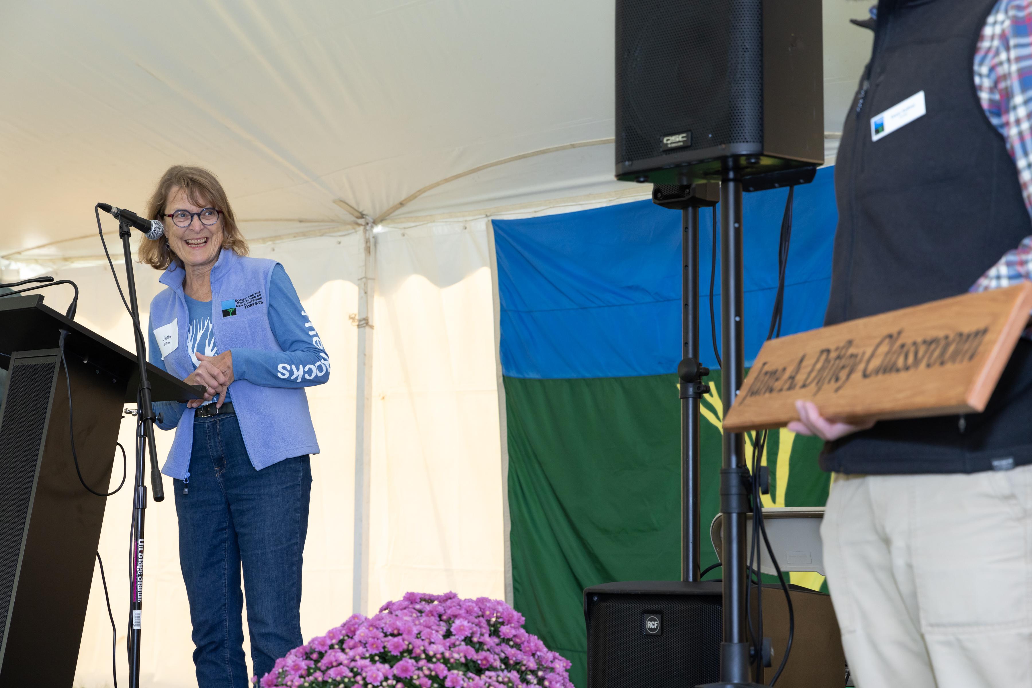 Jane Difley reacts to the classroom sign and says a few words on stage.