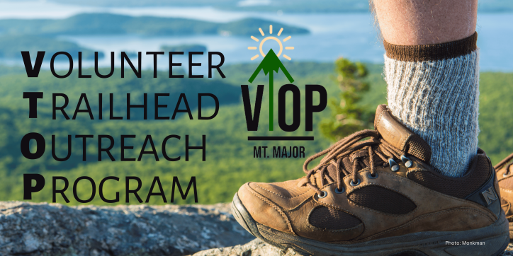 View of the lake from the summit of Mount Major with a hiker's boot and text that reads Volunteer Trailhead Outreach Program.