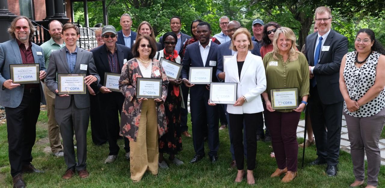 Recipients stand holding their certificates.