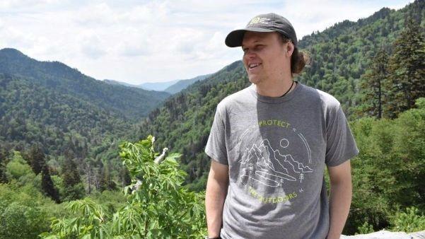 Cam Larnerd poses for a photo outdoors with mountains in the background.