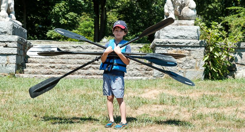 Kid carrying oars at Gundalow River Rats camp environmental and outdoor education