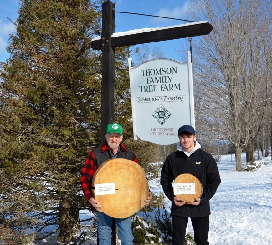 Tom Thomson owner of the Thomson Family Tree Farm with grandson Jaden Thomson. Both are holding tree "cookies' in front of a sign for Thomson Tree Farm. (Courtesy of Tom Thomson)