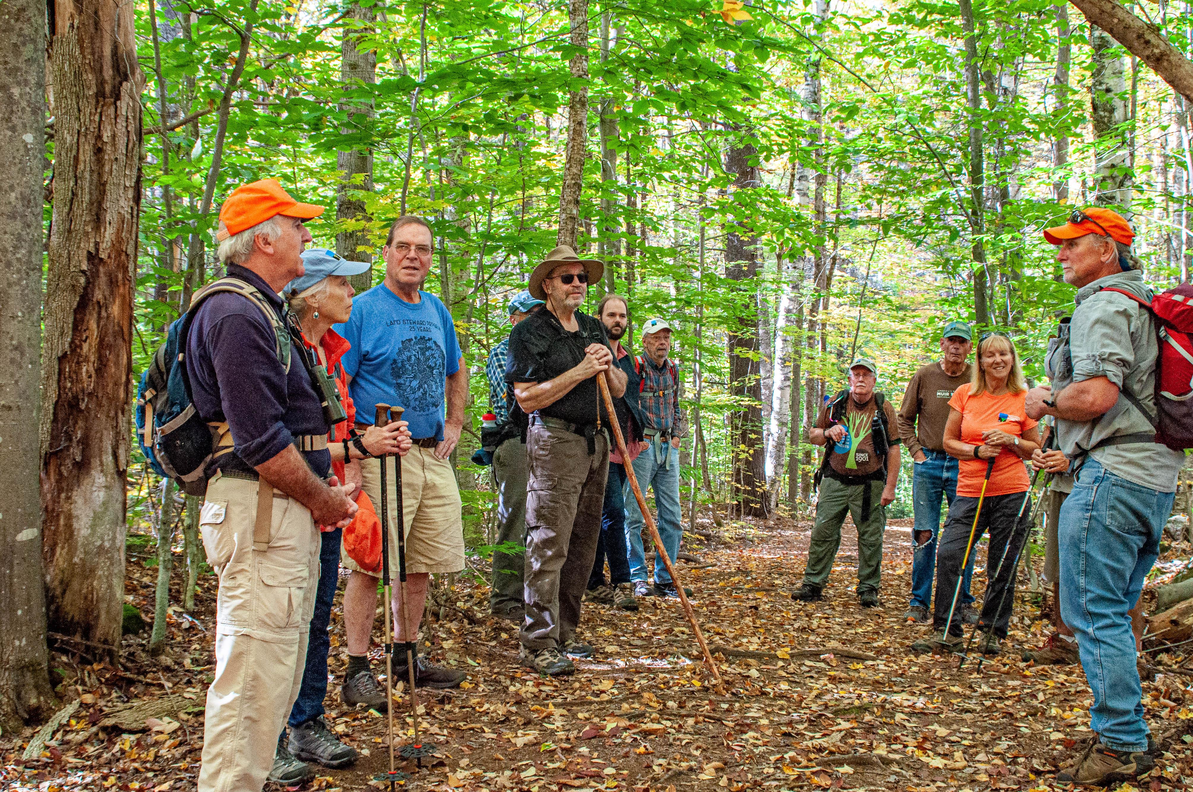 Dave Anderson talks to a group of volunteers in the woods at Hay Reservation