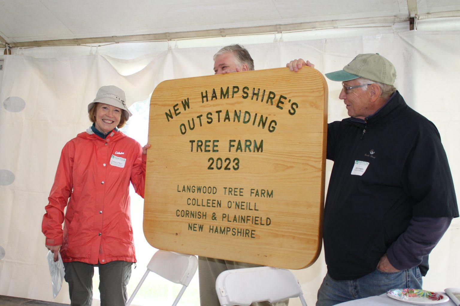 Colleen O'Neill accepts the large wooden sign at the event.