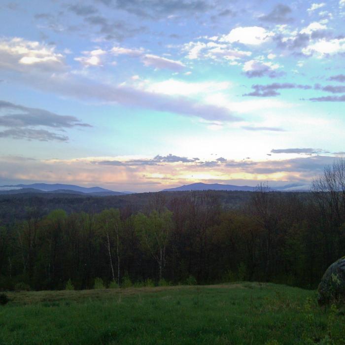 The sun sets over a mountain view from The Rocks.