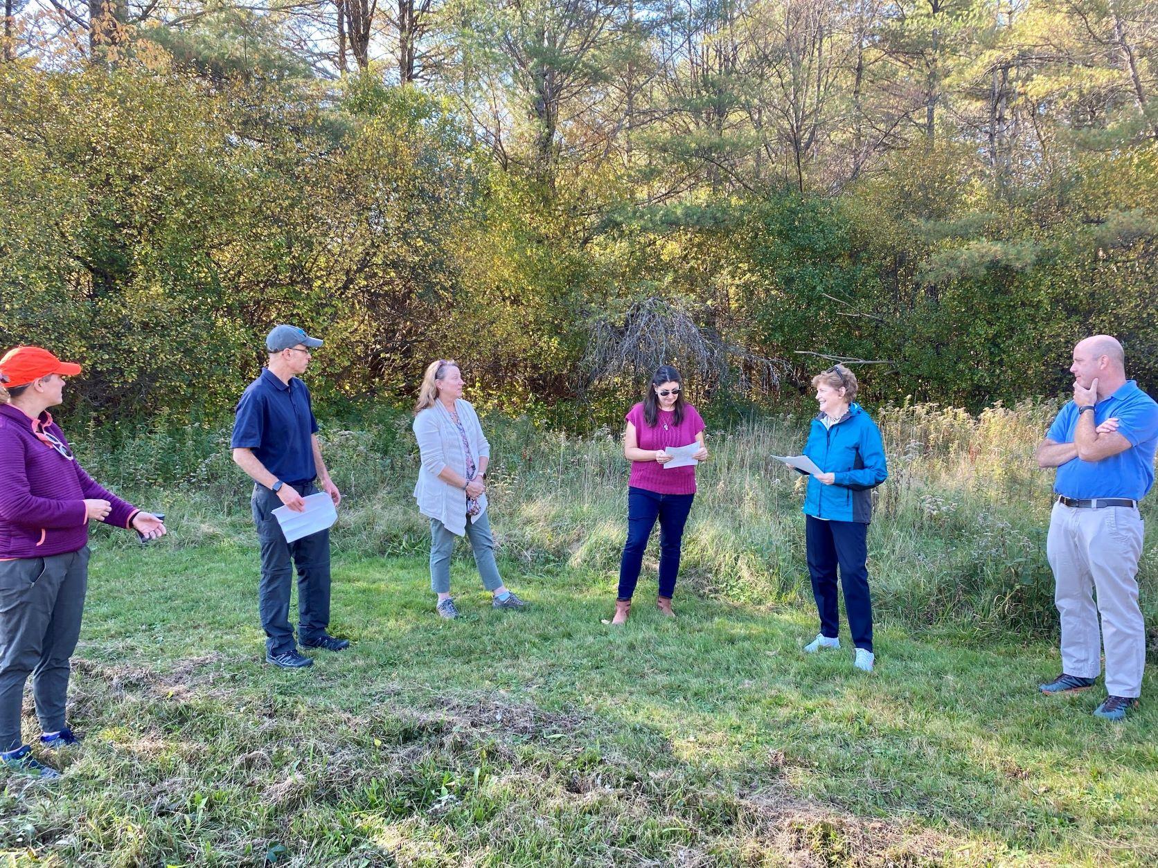 Senator Shaheen stands in the middle of a circle of conservation leaders outdoors at Mink Brook Forest.