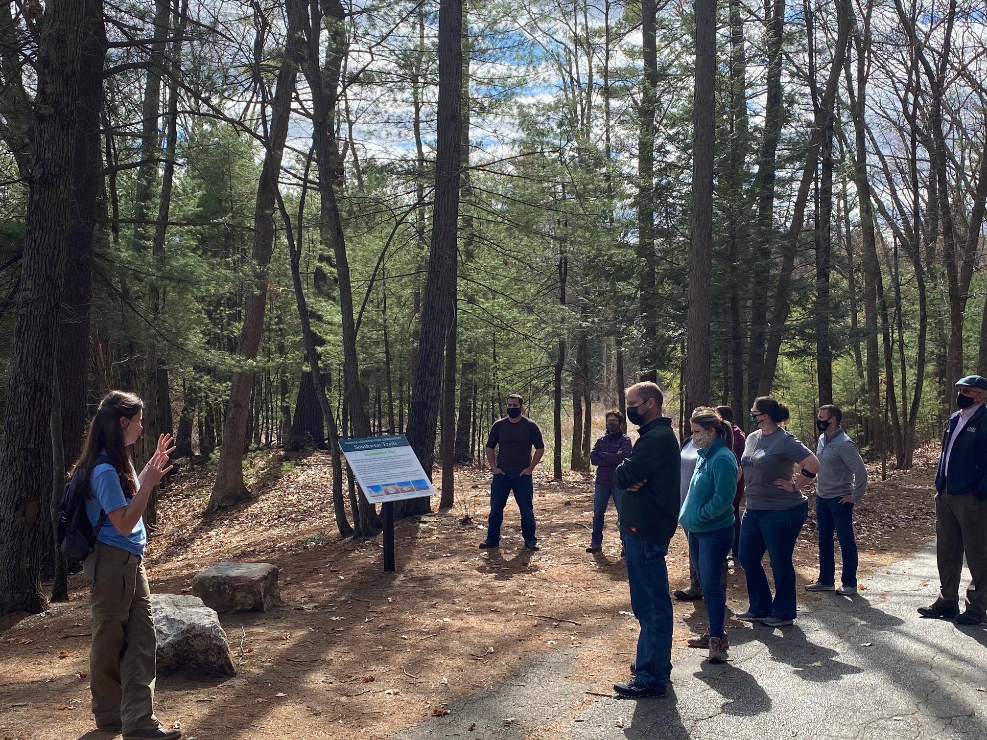 Group listens to Stacie Hernandez at scenic Lovewell Pond