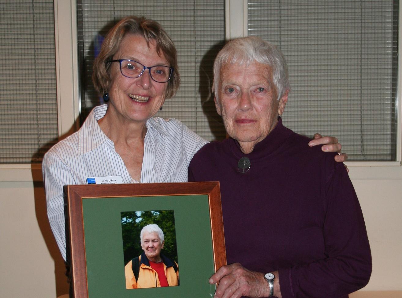 Jane Difley and Martha Chandler pose together with a plaque between them.