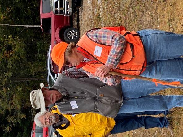 Tree Farmers Ann (orange) and Mark (hat) Davis