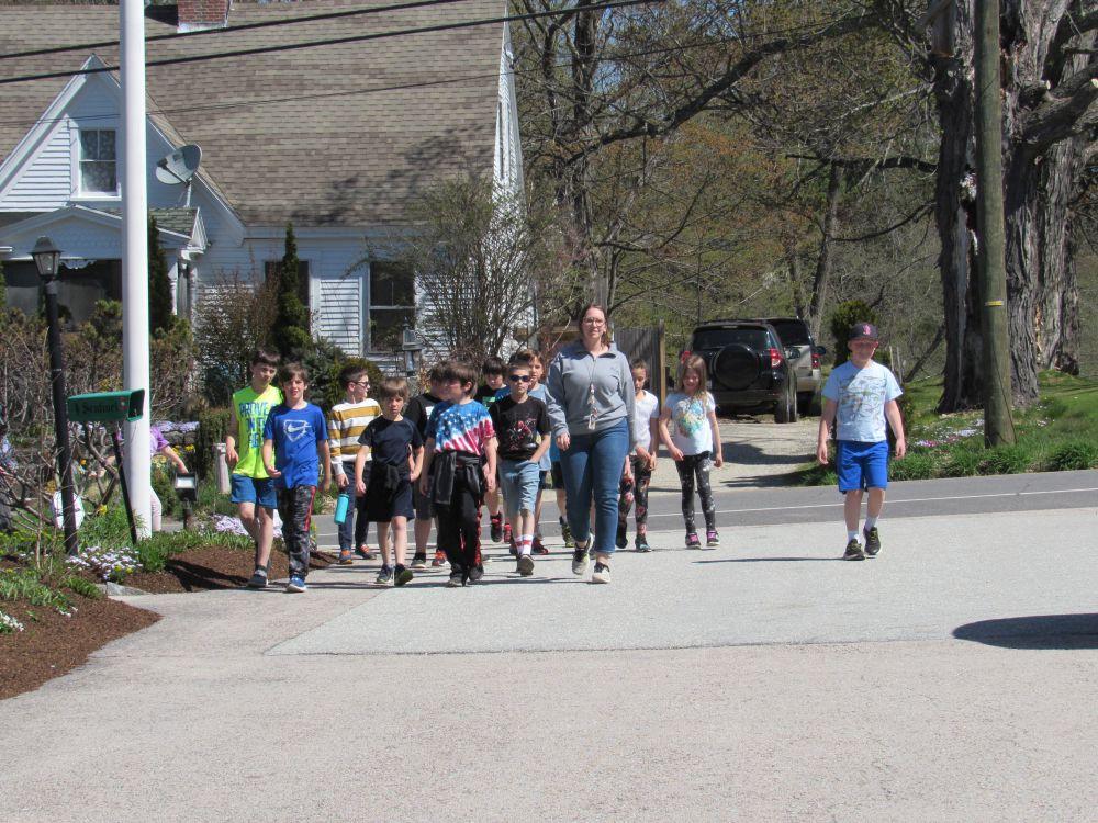 students walking sidewalk to field trip site