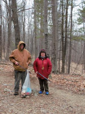 Parents hold a trash bag along the trail at Mount Major.