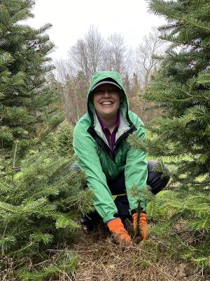 A volunteer stops to smile while planting seedlings.