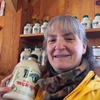 Kate Wilcox holds a bottle of maple syrup.