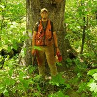 Ian Aldrich poses in front of a tree.