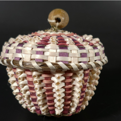 A pink and white basket woven from ash.