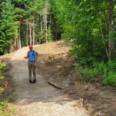 A forest society staff member stands on the new trail.