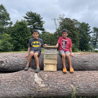 Two children pose with a bat box they made last summer out of the wood.