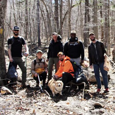 A team from Pine Line Outdoor LLC poses on the Brook Trail with trash they've picked up.