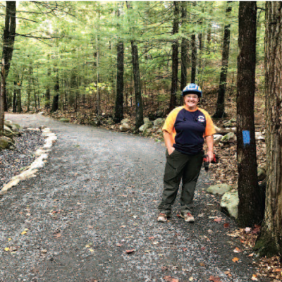 Erin Amadon, of Town 4 Trail Services LLC, poses next to the upgraded trail.