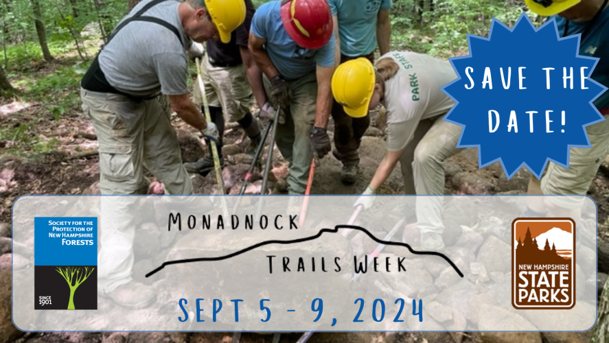A group of individuals with tools pushing a large rock to advertise the dates for the upcoming Monadnock Trails Week. September 5-9, 2024. A collaboration between the Forest Society and NH State Parks.