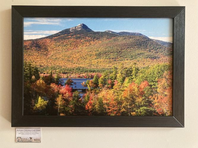 a framed photograph of a lake and mountain during autumn 