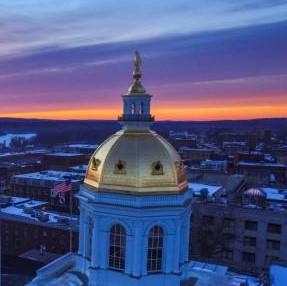 NH State Capital dome against sunrise sky