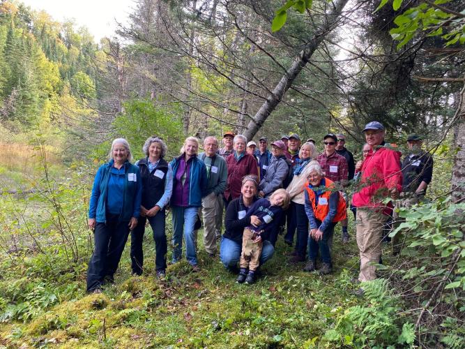 Attendees of the Ammonsoosuc River Forest field trip pose together in the woods.