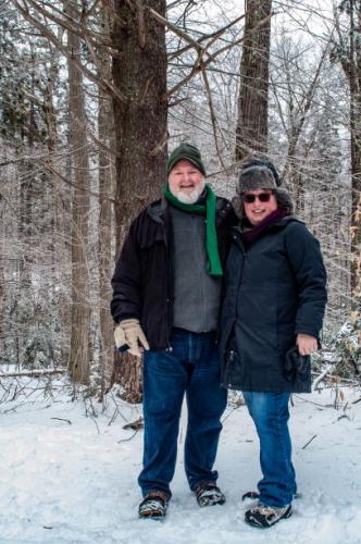 A couple poses together on the snowy trail.