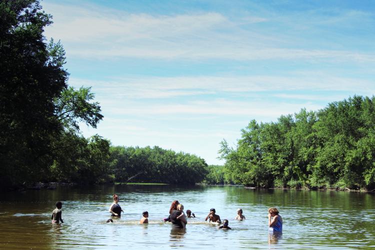 Students splash in the Merrimack River.