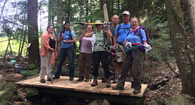 Volunteer show off a newly completed hiking bridge at Monadnock Trails Week