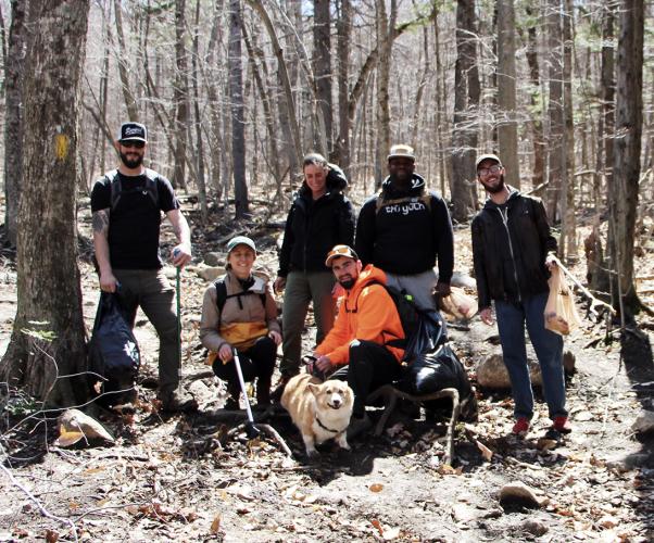 A team from Pine Line Outdoor LLC poses on the Brook Trail with trash they've picked up.