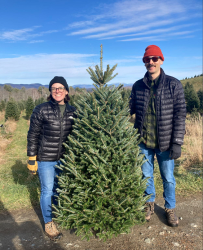 A couple poses with their fresh-cut Christmas tree at The Rocks.
