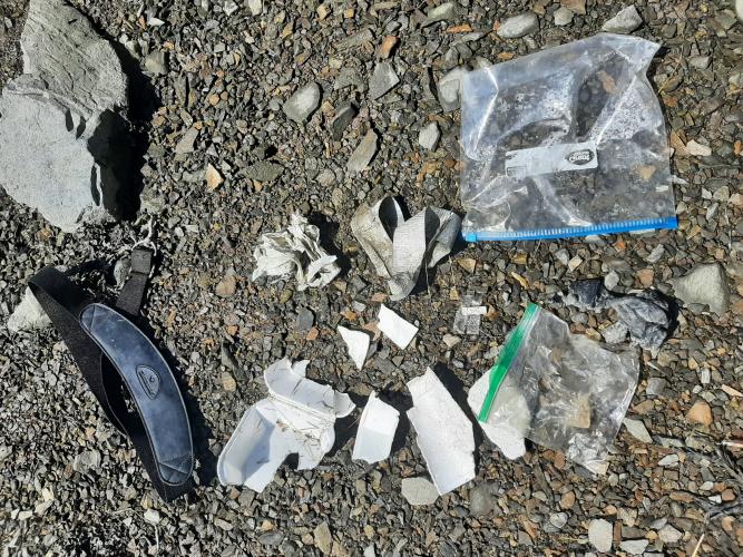 Items of litter laid out on a stony beach