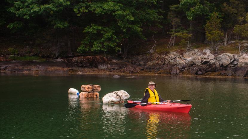 Volunteer comes up with creative way to tow trash in a kayak