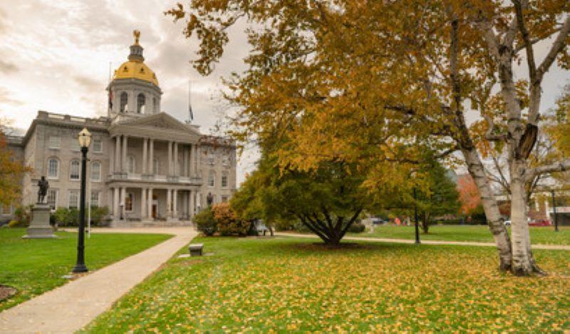 NH State House with fall leaves and colors blue sky