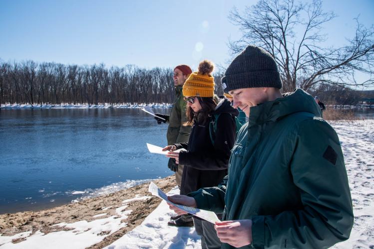 UNH grad students in parkas survey from bank of Merrimack River