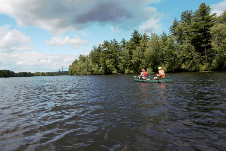 Two people in a canoe on the Merrimack River.
